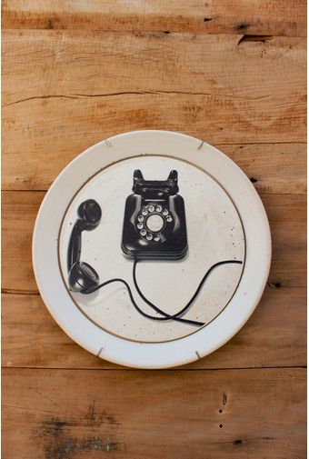 prato de concreto branco com estampa de telefone preto retrô em fundo de madeira